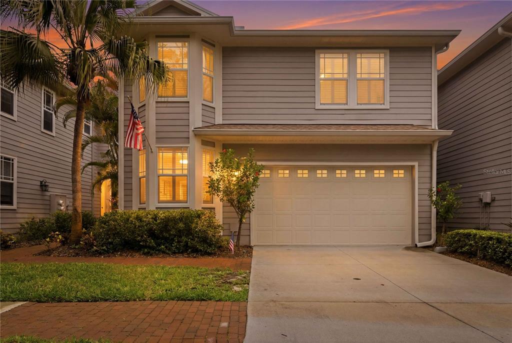 A two-story house with gray siding, a single-car garage, and a palm tree in front — 2869 BAYSHORE TRAILS DRIVE, TAMPA, FL