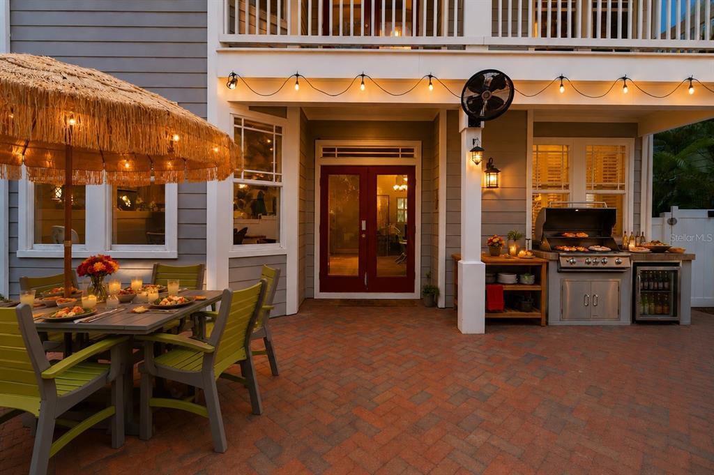A patio with a dining table, umbrella, and outdoor kitchen area under a covered porch — 2869 BAYSHORE TRAILS DRIVE, TAMPA, FL