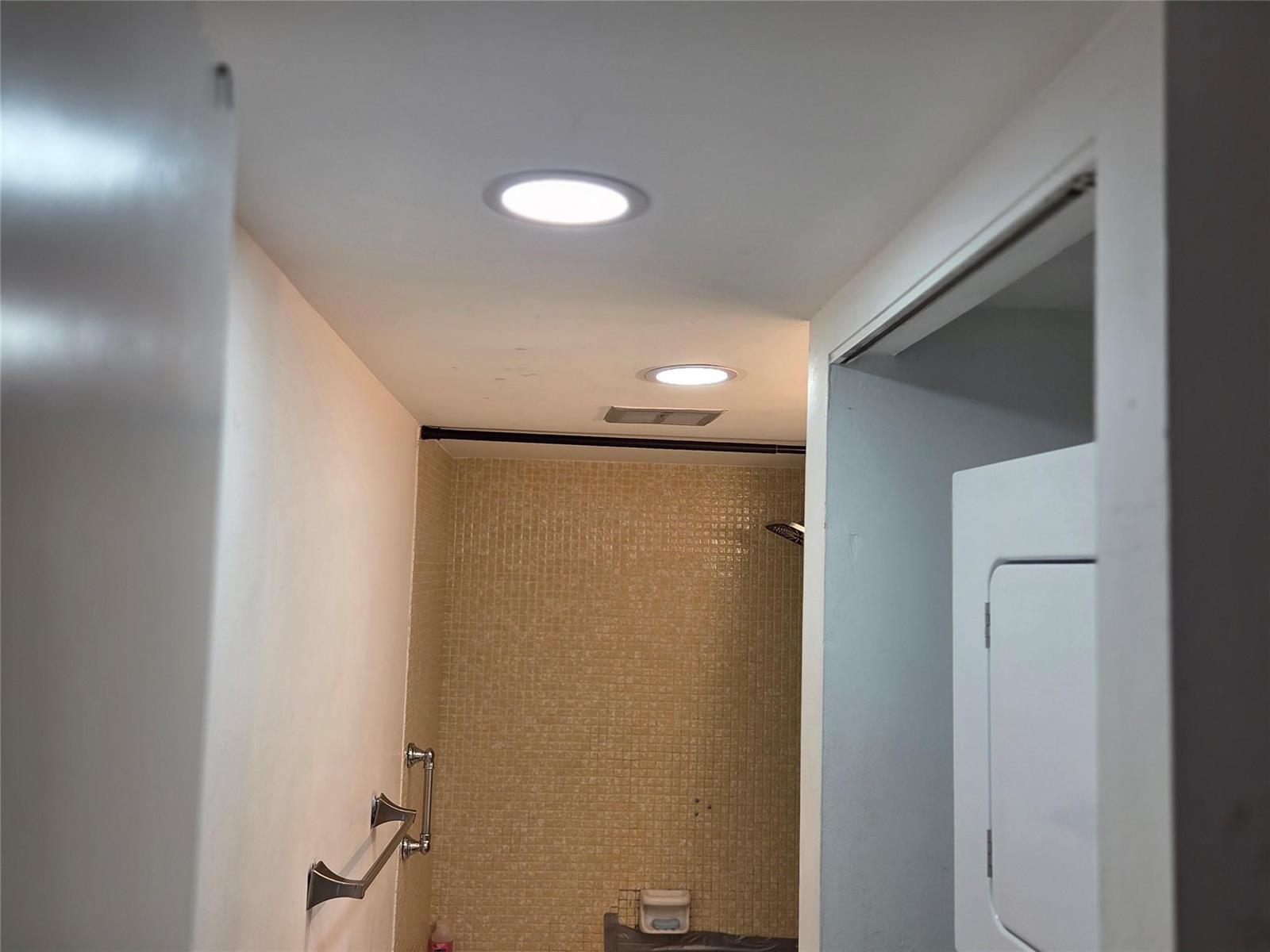 A bathroom features a tiled shower area, recessed ceiling lights, and a towel rack — 4152 Inverrary Drive # 310, Lauderhill FL 33319, LAUDERHILL, FL