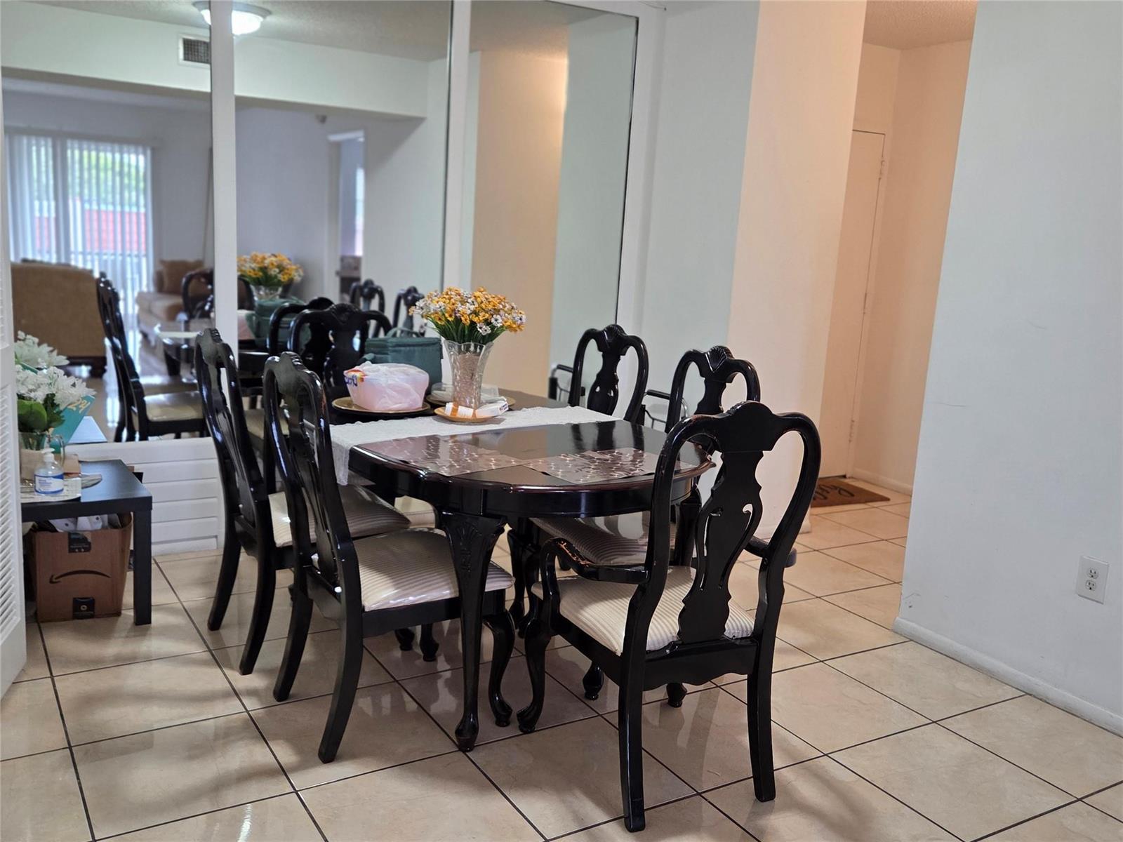 A dining room features a dark wood table with matching chairs and a mirrored wall — 4152 Inverrary Drive # 310, Lauderhill FL 33319, LAUDERHILL, FL