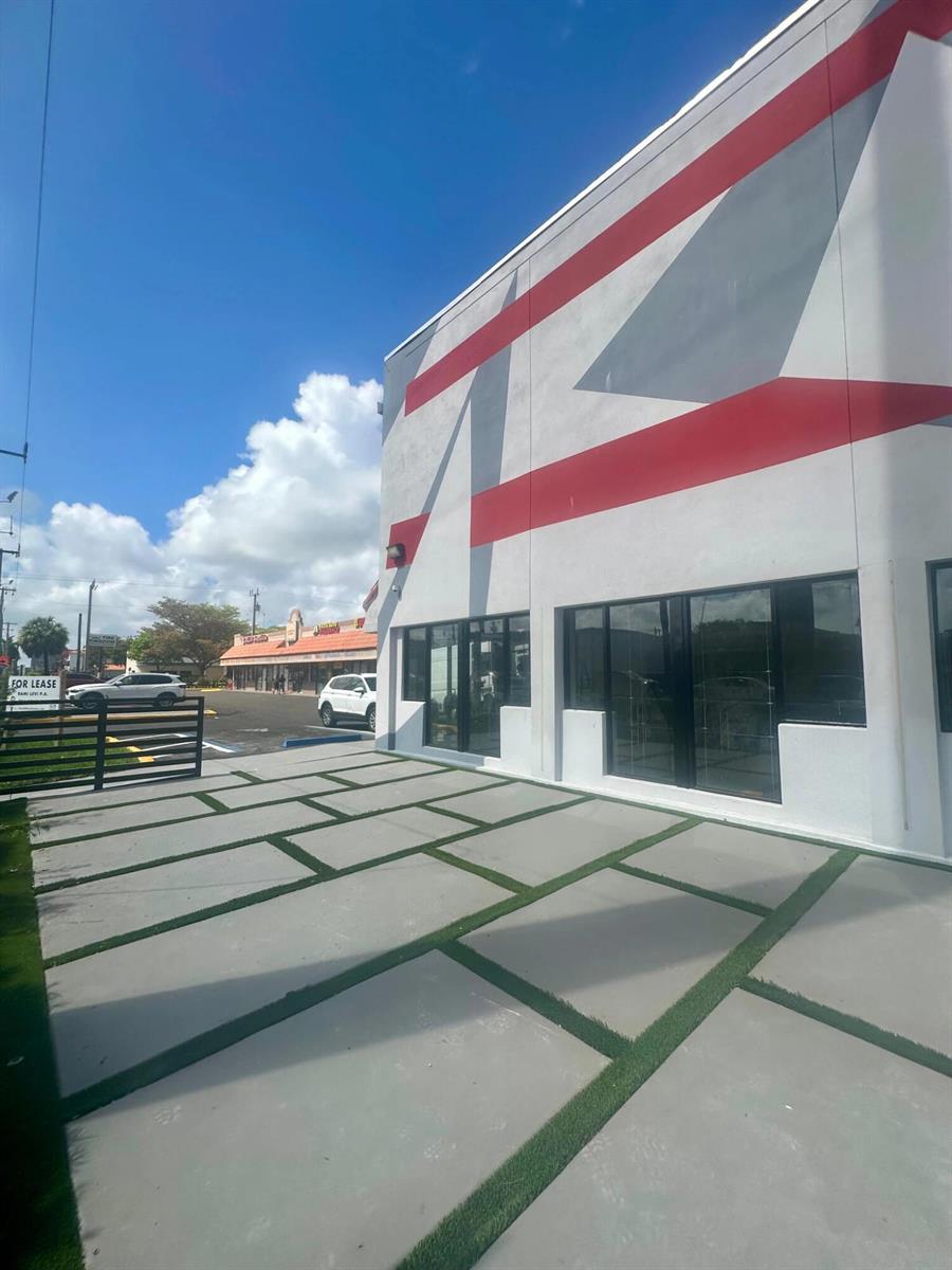 A modern commercial building exterior features a geometric red and gray mural and paver patio — 9 N Dixie Highway, Hallandale Beach FL 33009, HALLANDALE BEACH, FL