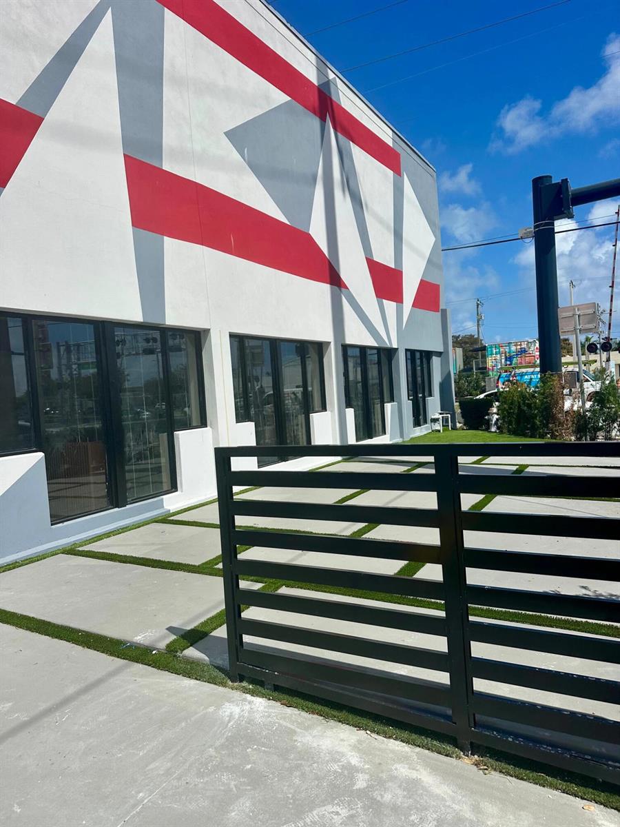 A modern building exterior features a geometric red and gray mural above glass storefront doors — 9 N Dixie Highway, Hallandale Beach FL 33009, HALLANDALE BEACH, FL