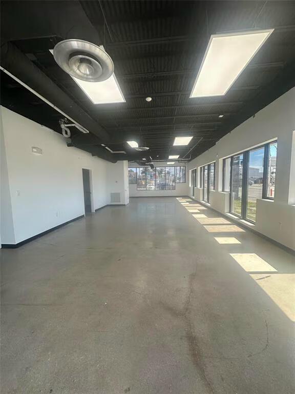 An empty commercial space features a black exposed ceiling, polished concrete floors, and large windows — 9 N Dixie Highway, Hallandale Beach FL 33009, HALLANDALE BEACH, FL