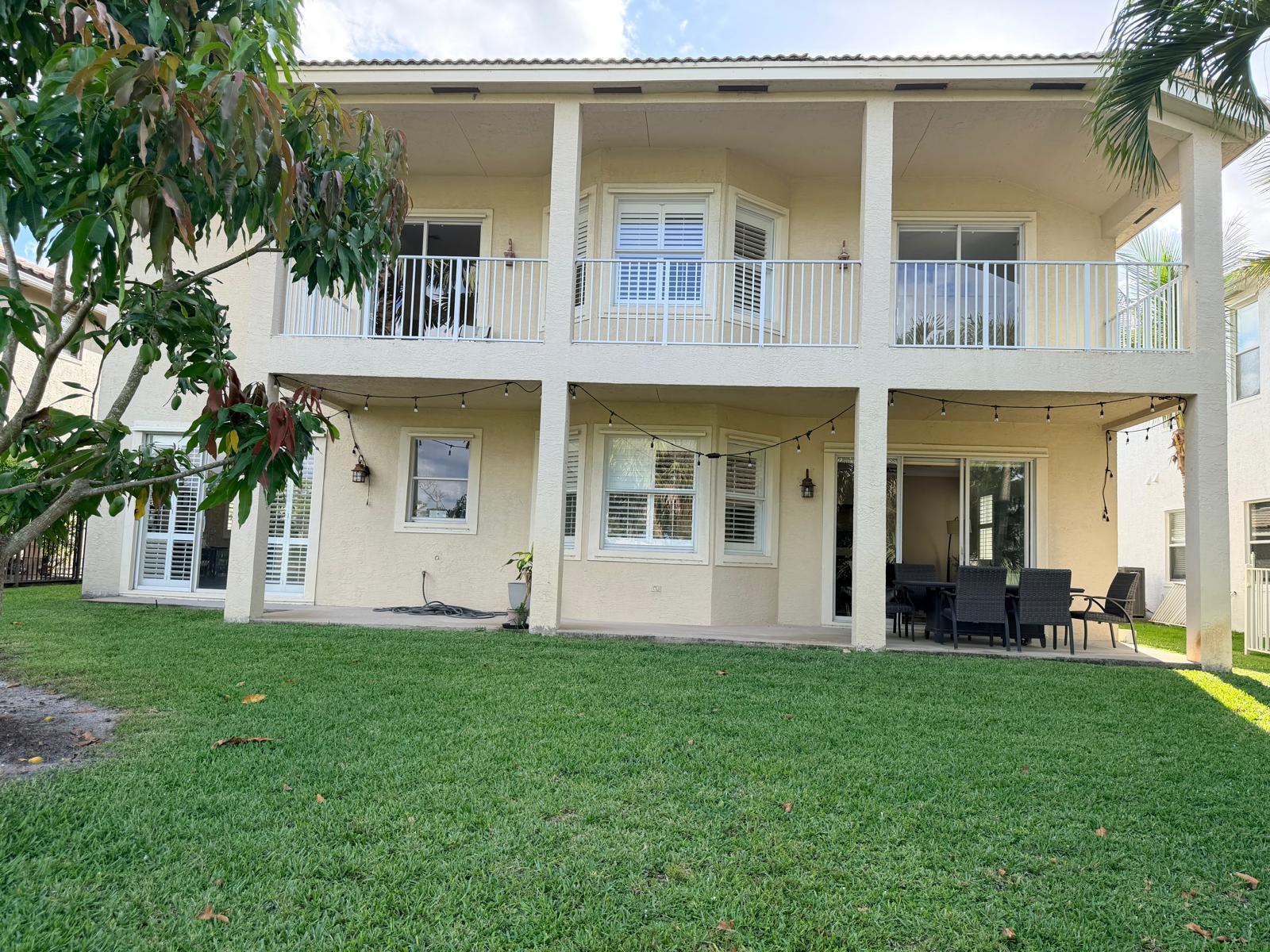 A kitchen with white cabinets, black countertops, a wooden island, and hardwood floors — 2285 Ridgewood Circle, Royal Palm Beach FL 33411, ROYAL PALM BEACH, FL