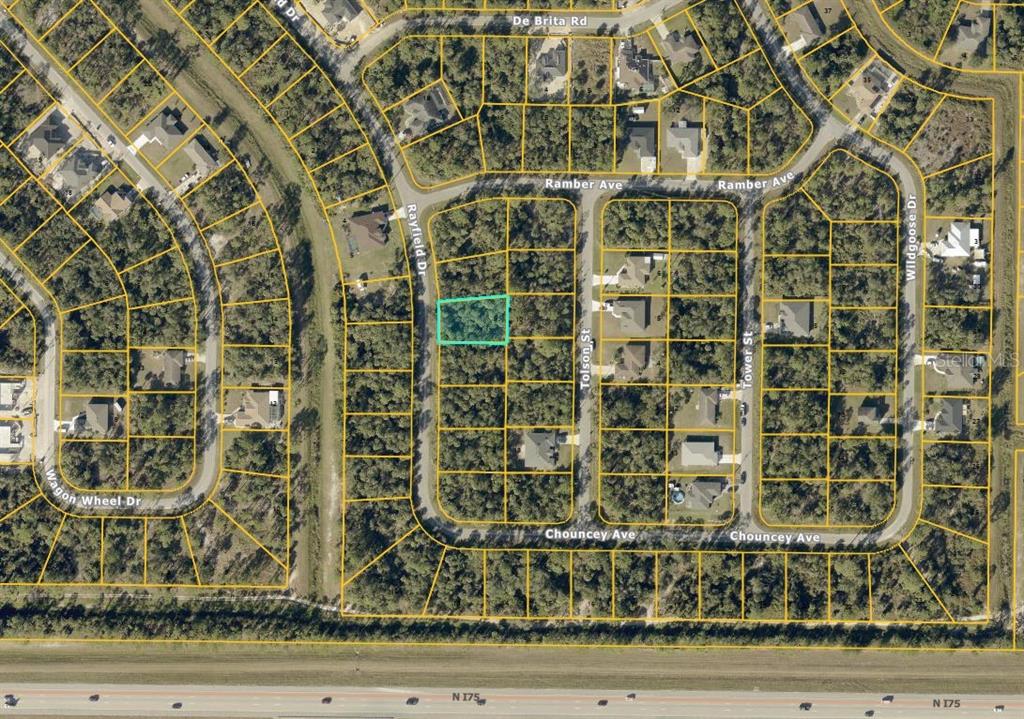 This is an aerial map showing a vacant, rectangular lot highlighted in green within a neighborhood — RAYFIELD DR, NORTH PORT, FL
