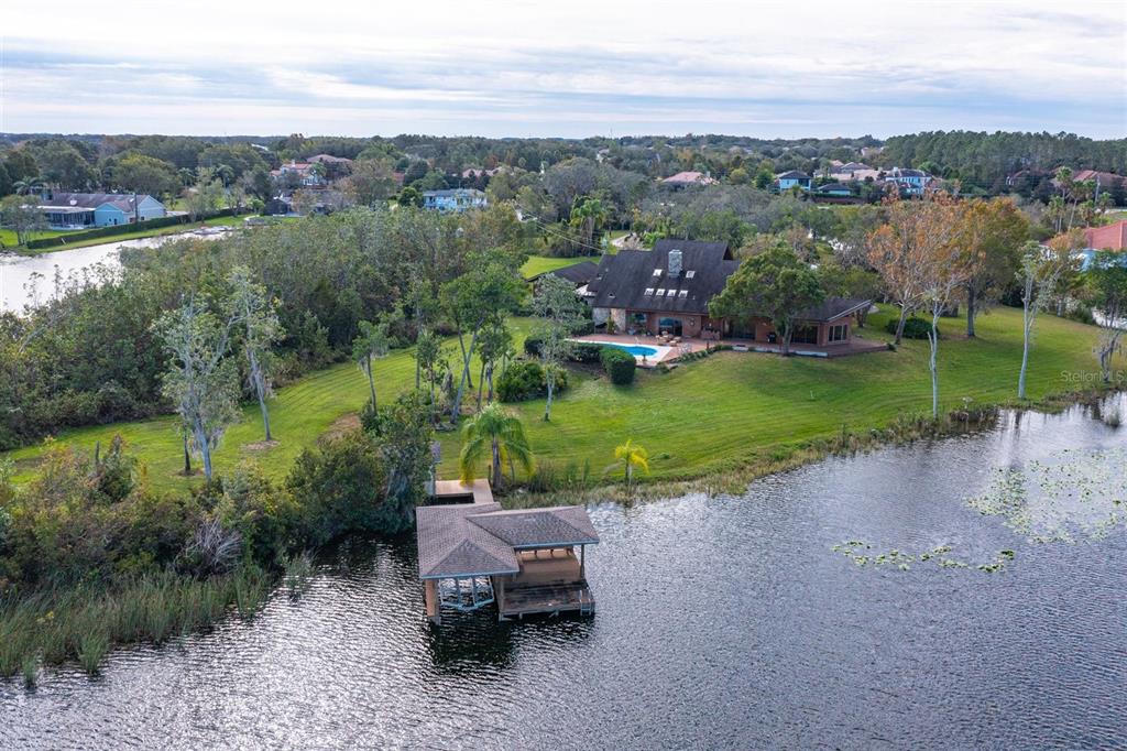 An aerial view shows a house with a pool and a boat dock on a lake — 13377 LAKE BUTLER BOULEVARD, WINTER GARDEN, FL