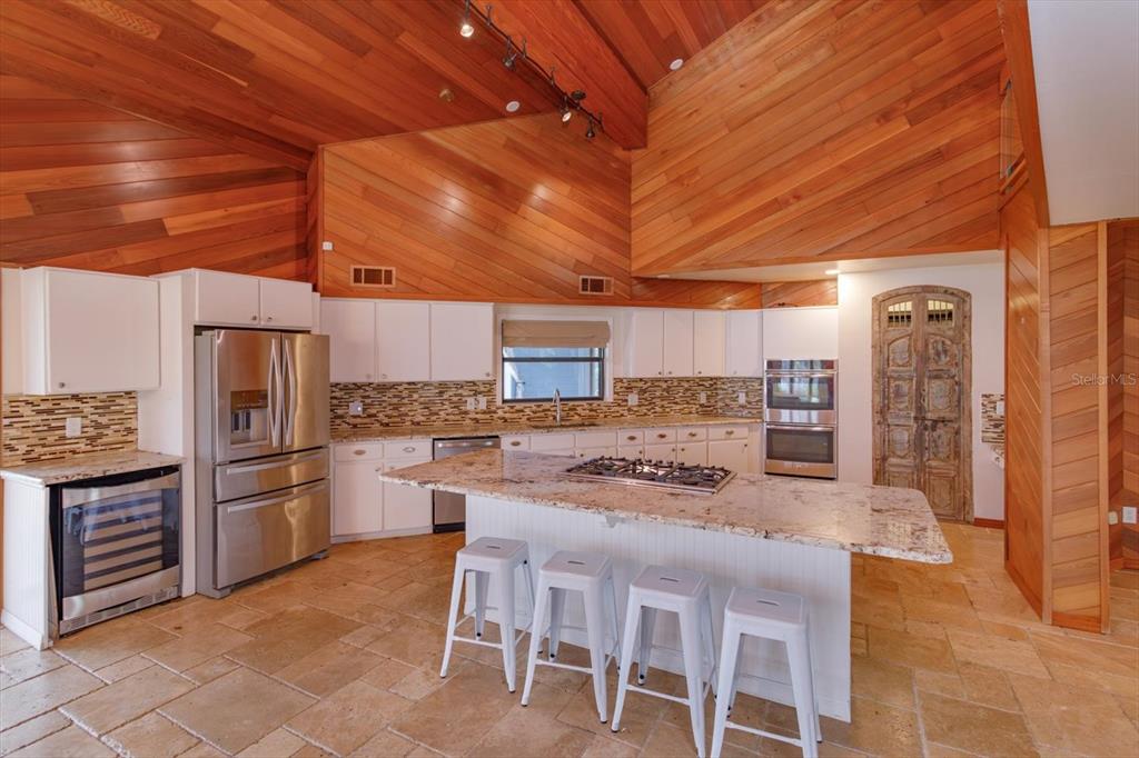 A kitchen with white cabinets, granite countertops, a center island, and wood-paneled vaulted ceilings — 13377 LAKE BUTLER BOULEVARD, WINTER GARDEN, FL