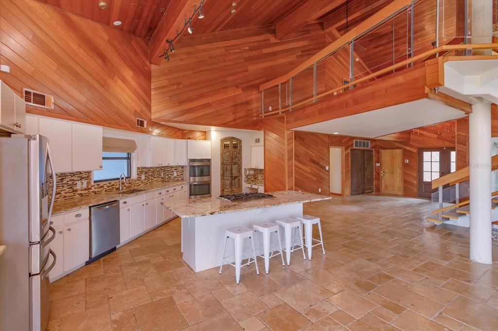 A kitchen with white cabinets, granite countertops, and a center island with four bar stools — 13377 LAKE BUTLER BOULEVARD, WINTER GARDEN, FL