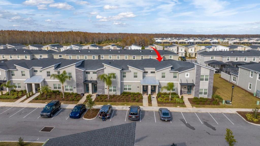 An aerial view shows a multi-unit townhouse building with gray siding and a parking lot — 4337 QUOTE STREET, KISSIMMEE, FL