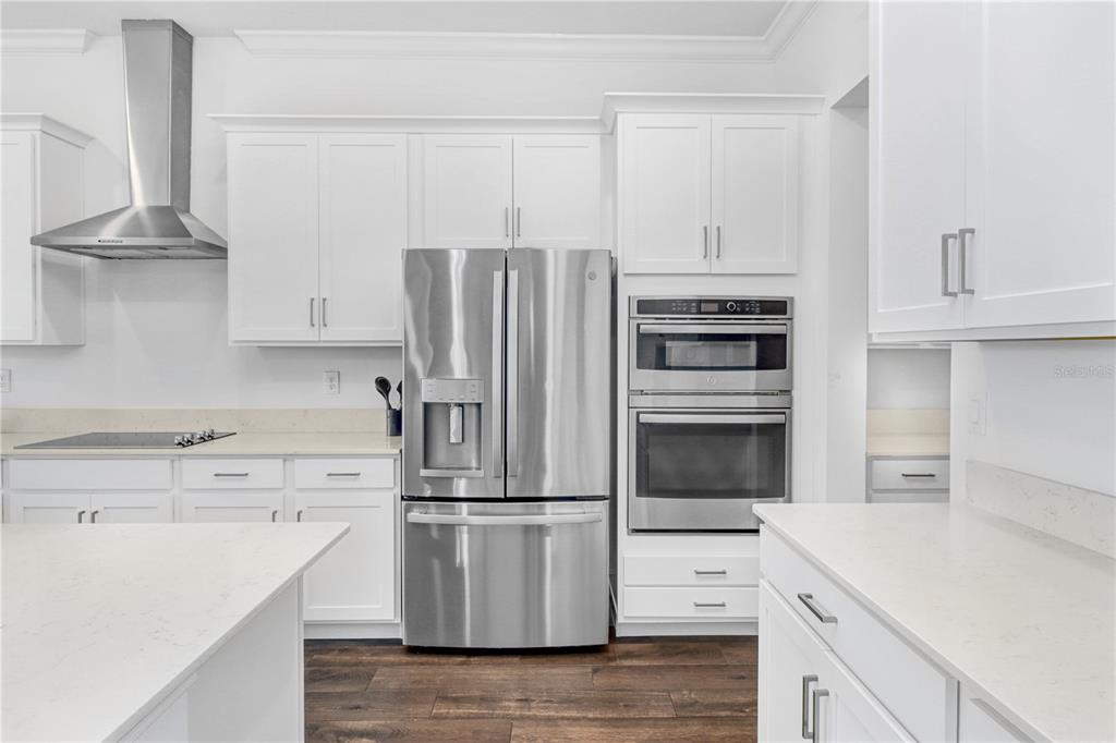A modern kitchen features white cabinetry, stainless steel appliances, and a central island — 12876 BERGSTROM BAY DRIVE, RIVERVIEW, FL