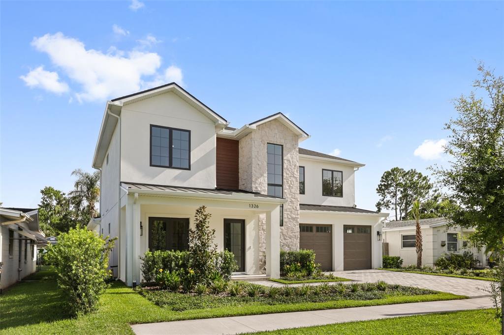 A two-story house with a stone facade, white siding, and a two-car garage — 1326 W NEW HAMPSHIRE STREET, ORLANDO, FL