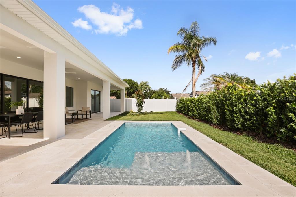 A rectangular swimming pool sits on a patio next to a covered porch and lawn — 1326 W NEW HAMPSHIRE STREET, ORLANDO, FL