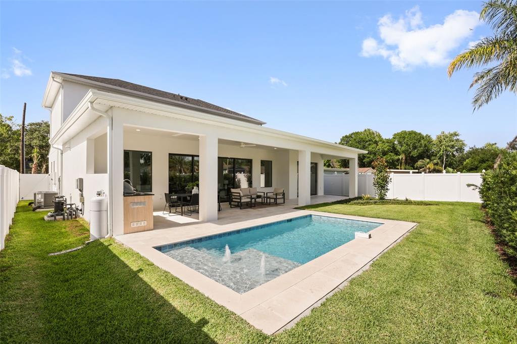 A white house with a covered patio, outdoor kitchen, and a rectangular swimming pool — 1326 W NEW HAMPSHIRE STREET, ORLANDO, FL