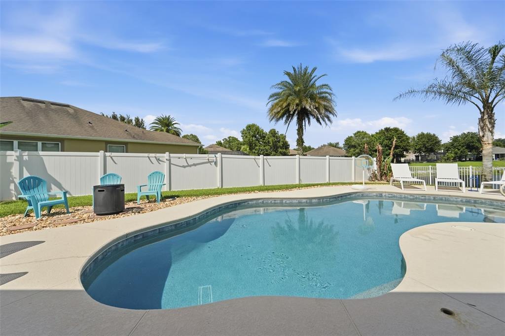 A single-story house with a stone facade, beige garage doors, and a paved driveway — 471 BREEDERS CUP COURT, DELAND, FL