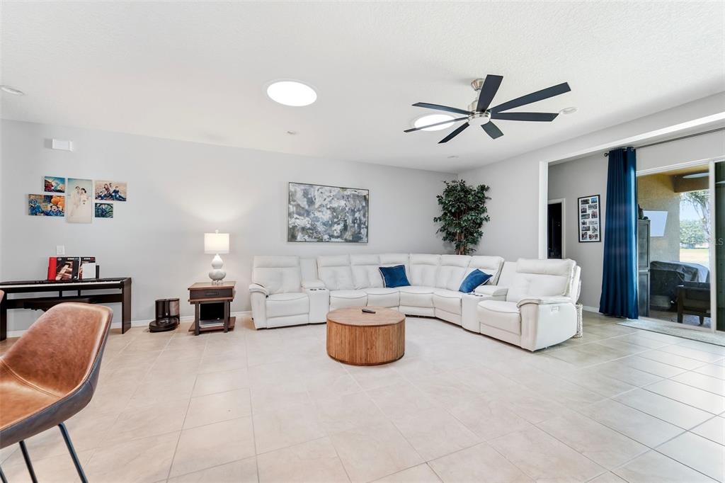 A grassy backyard features a white fence, a palm tree, and a view of a pond — 471 BREEDERS CUP COURT, DELAND, FL