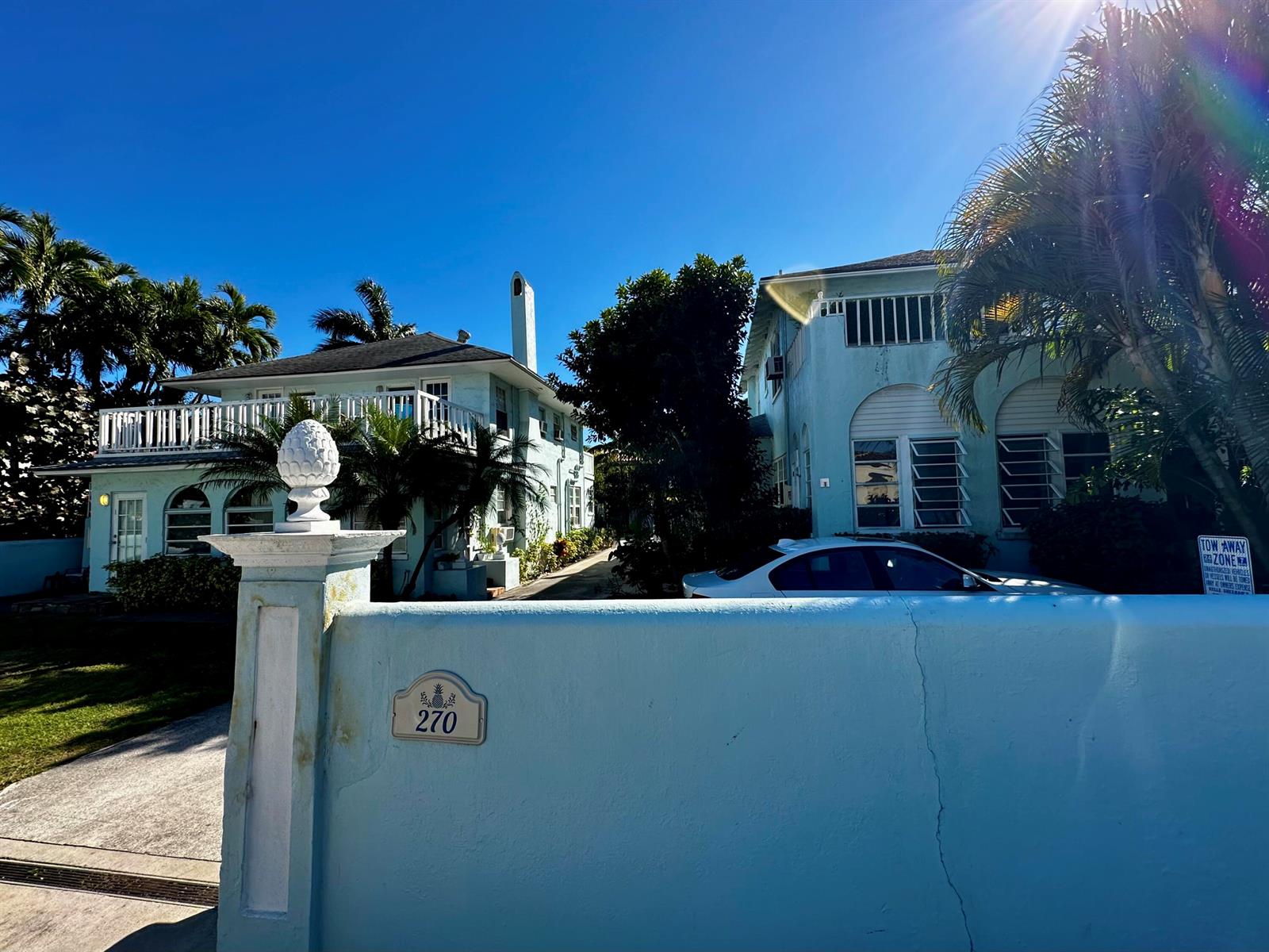 A light blue building with a white wall and pineapple finial stands under a clear sky — 270 Seminole Avenue # 3, Palm Beach FL 33480, PALM BEACH, FL