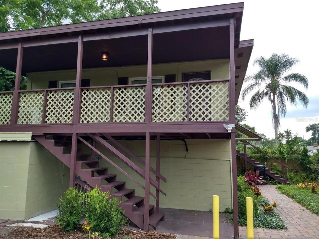 An elevated house with a wooden porch, lattice railings, and an outdoor staircase — 2512 MUSSELWHITE AVENUE UNIT #1, ORLANDO, FL
