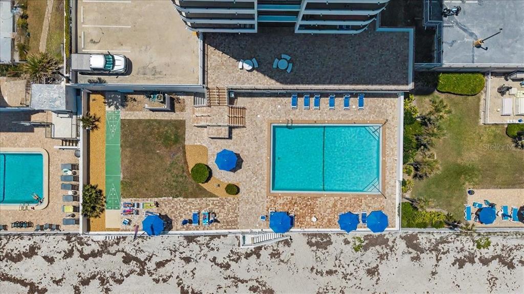 An aerial view shows a swimming pool, patio area, shuffleboard court, and beach access — 3743 S ATLANTIC AVENUE UNIT 10B0, DAYTONA BEACH, FL