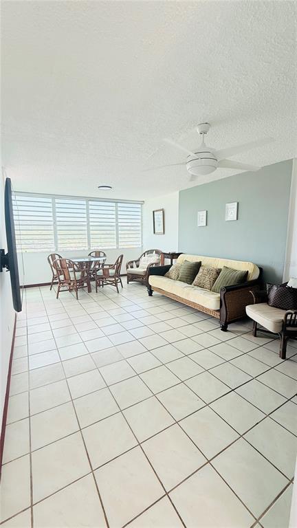 A sunroom features a light-colored tile floor, a ceiling fan, and a dining area — AVENIDA MARINA VIEW DOS MARINAS II UNIT 908, FAJARDO, PR