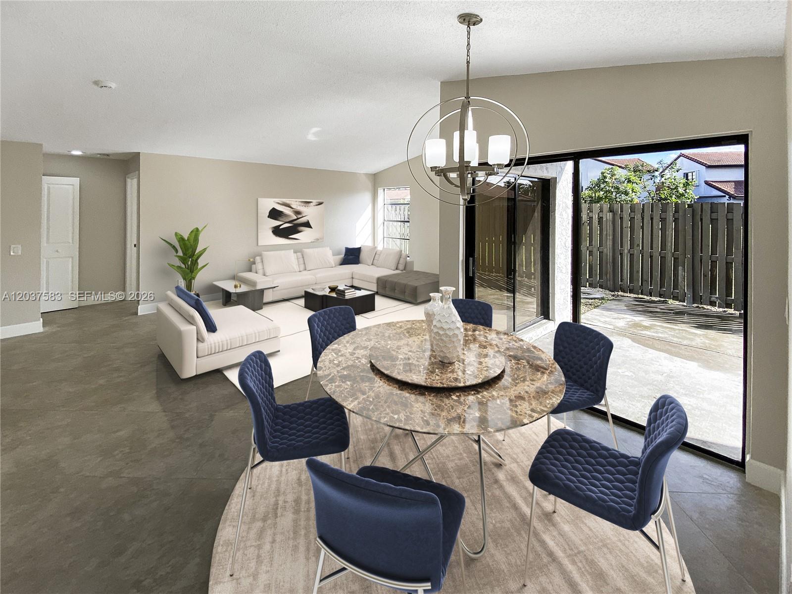 This living and dining area features a marble table, blue chairs, and a sliding door — 14980 SW 48th Ter # 28F, Miami FL 33185, MIAMI, FL