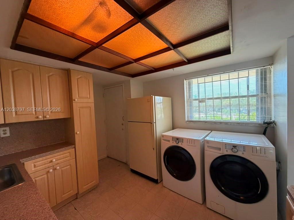 A kitchen features light wood cabinets, a refrigerator, a washer, a dryer, and a drop ceiling — 8775 Park Blvd # 318, Miami FL 33172, MIAMI, FL