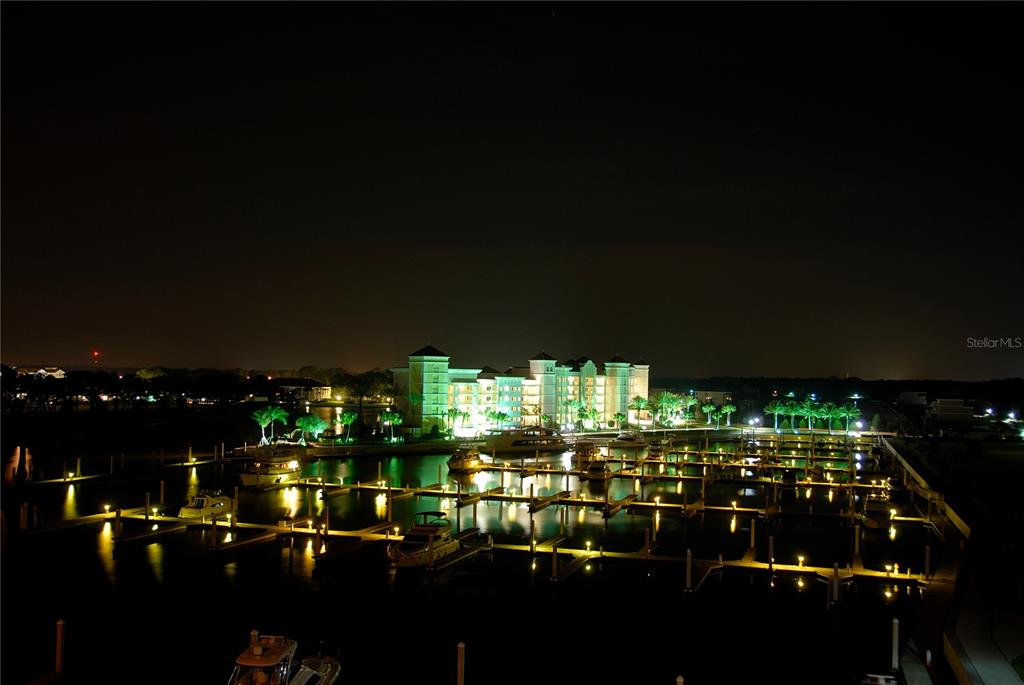 A night view of a marina with docked boats in front of a lit resort building — 282 YACHT HARBOR DRIVE, PALM COAST, FL