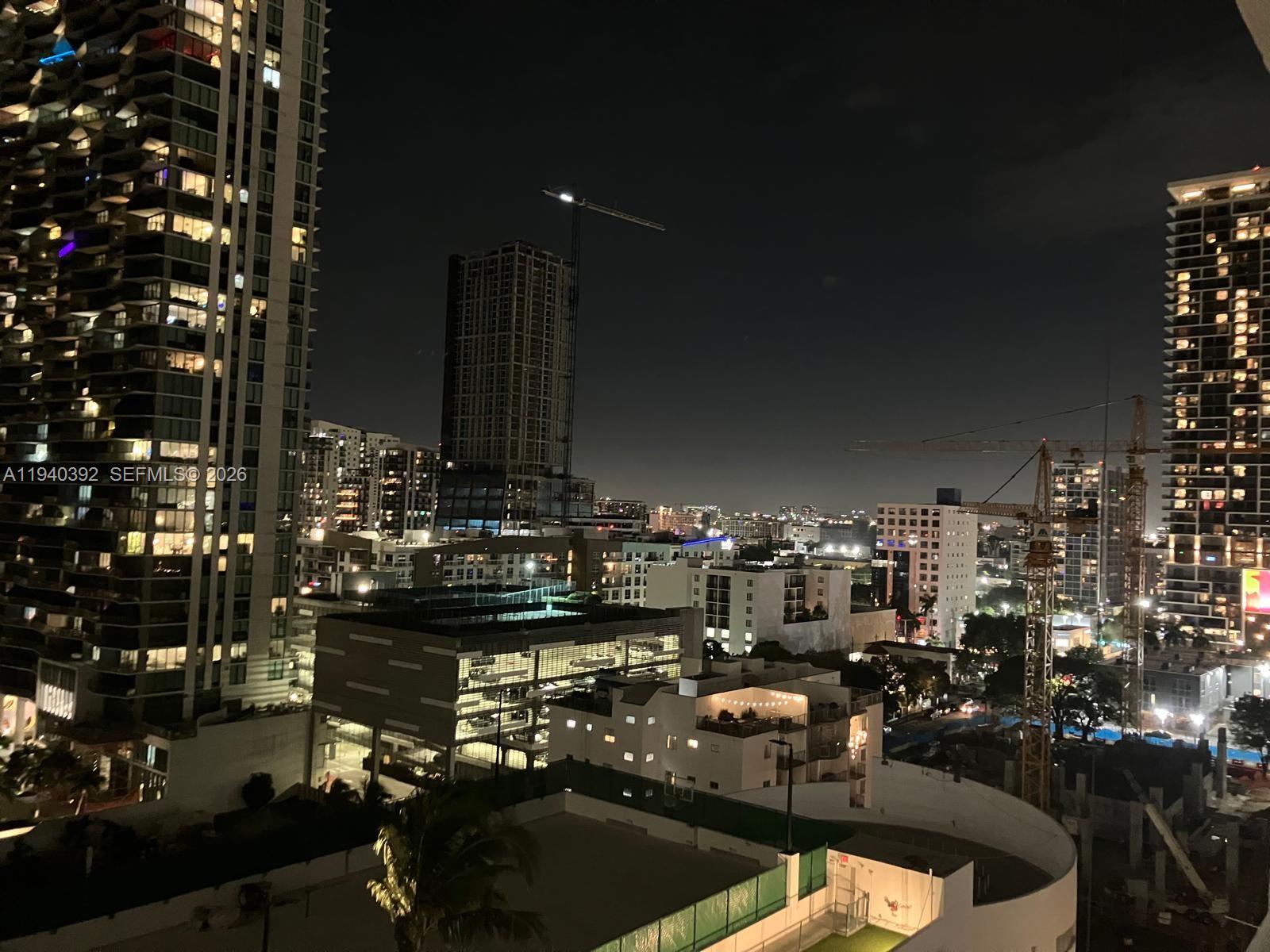 An elevated night view of a city skyline featuring several high-rise buildings and construction cranes — 480 NE 30th St # 1403, Miami FL 33137, MIAMI, FL
