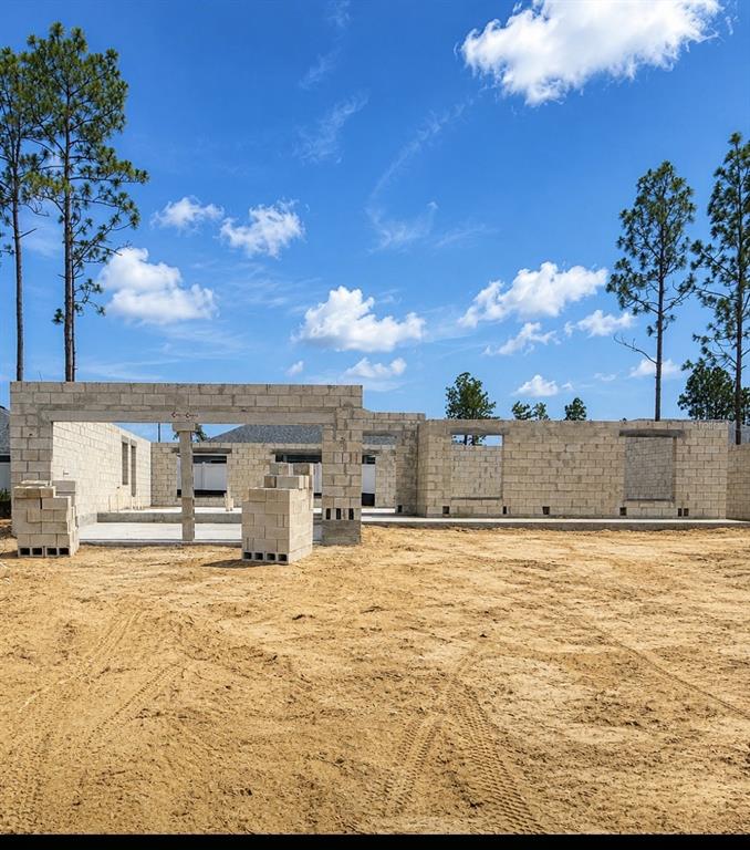 A construction site shows the concrete block walls of a house under a blue sky — 8433 N INCA, DUNNELLON, FL