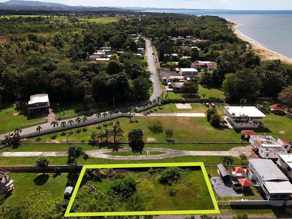 An aerial view shows a rectangular vacant lot outlined in green near a coastal road — CARRETERA 401, BO. PLAYA, ANASCO, PR