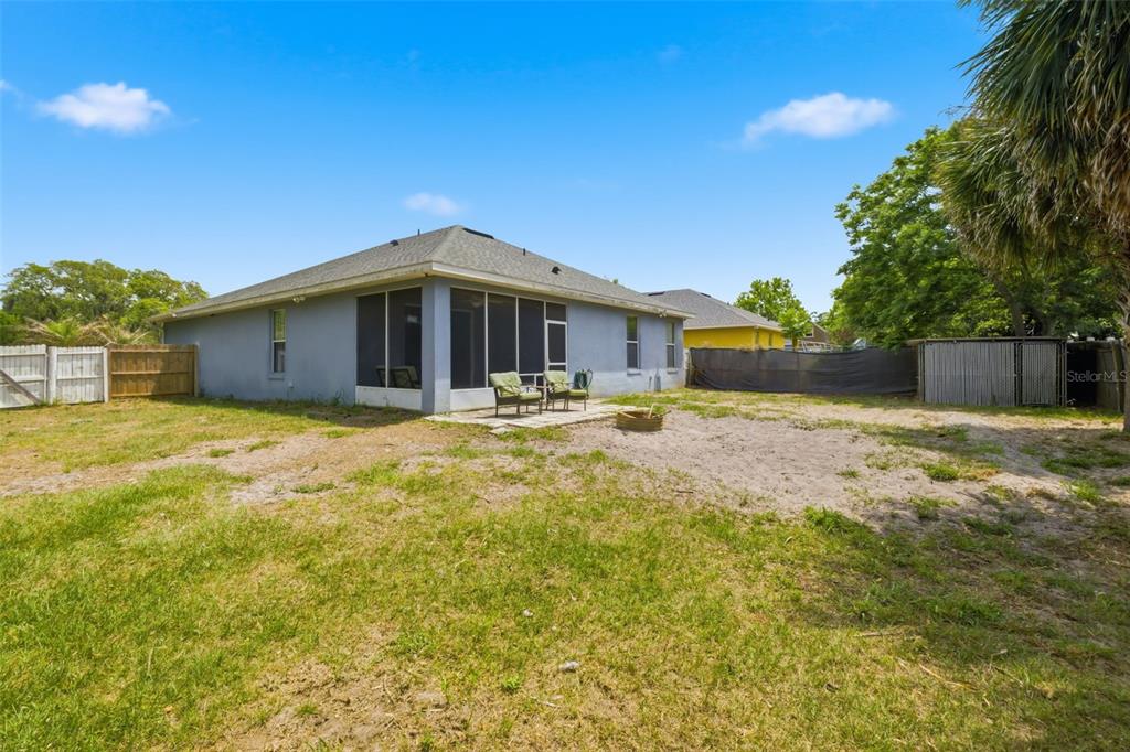 A screened-in porch with a concrete floor, ceiling fan, and views of a fenced backyard — 35937 DAWN DRIVE, LEESBURG, FL
