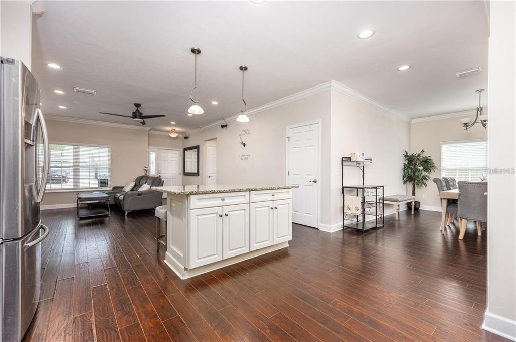 A kitchen with a white island and dark wood floors opens into a living area — 5504 NW 34TH STREET, GAINESVILLE, FL
