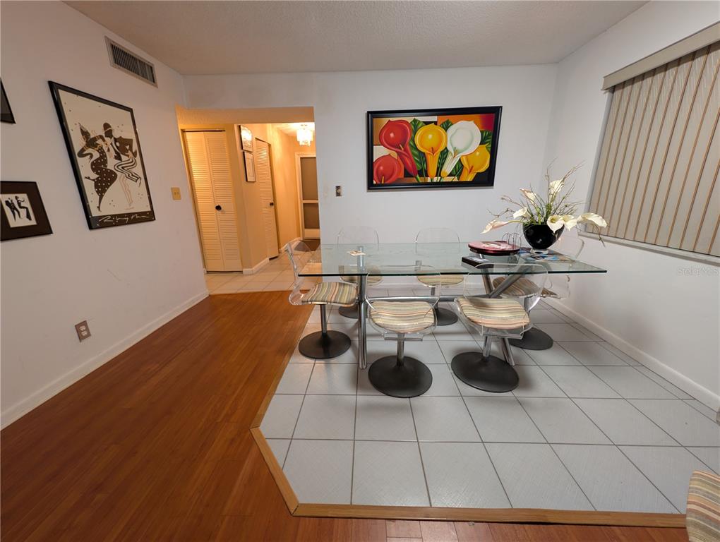 A dining area features a glass table with four chairs on a tiled floor inset — 6080 NW 44TH STREET UNIT 301, LAUDERHILL, FL