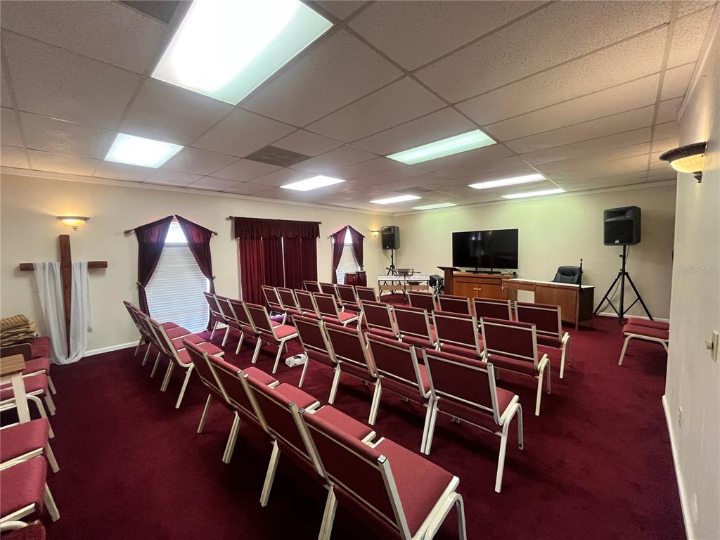 A room features wood-look flooring, a wooden bar counter, and a doorway to a red-carpeted room — 1165 1ST STREET S UNIT 1165, WINTER HAVEN, FL