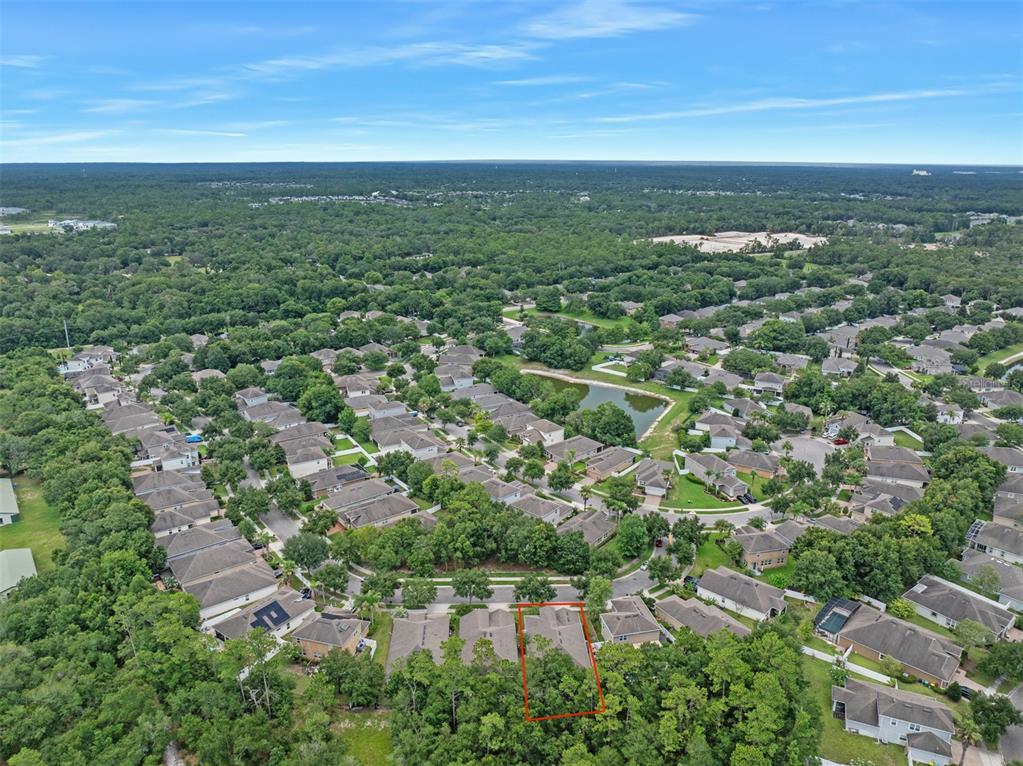 An aerial view shows a residential neighborhood with a highlighted house and surrounding trees — 740 PREAKNESS CIRCLE, DELAND, FL