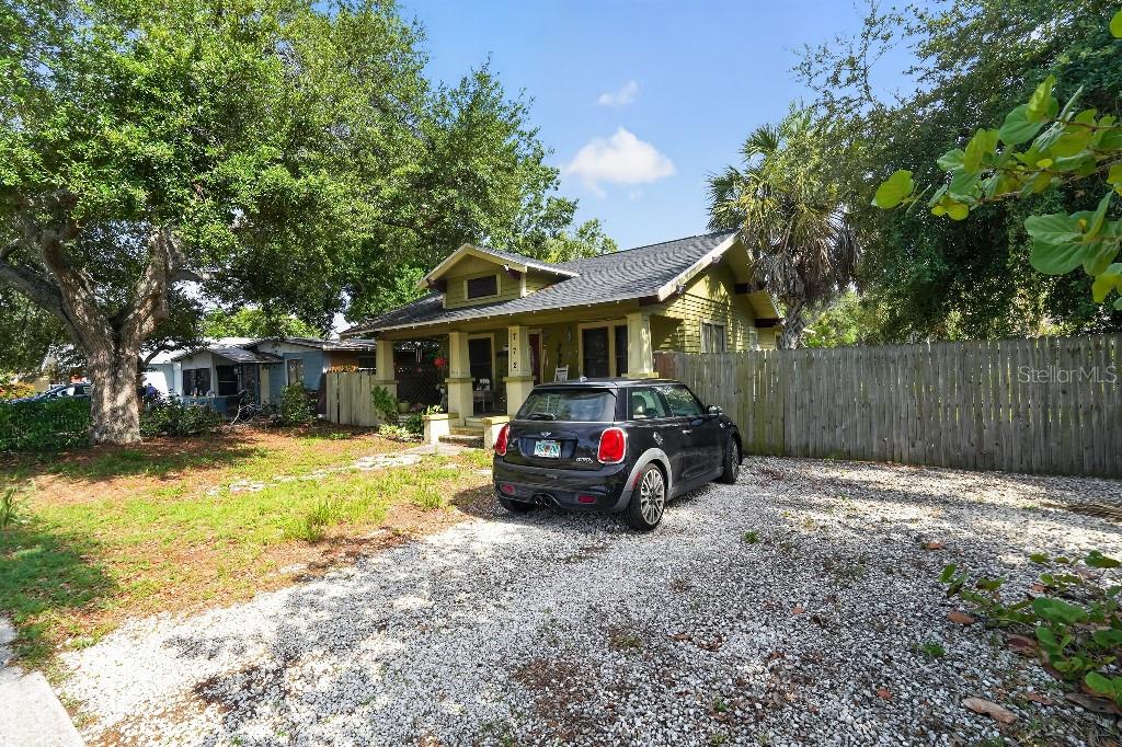 A black Mini Cooper is parked on a gravel driveway in front of a house — 772 38TH AVENUE S, ST PETERSBURG, FL