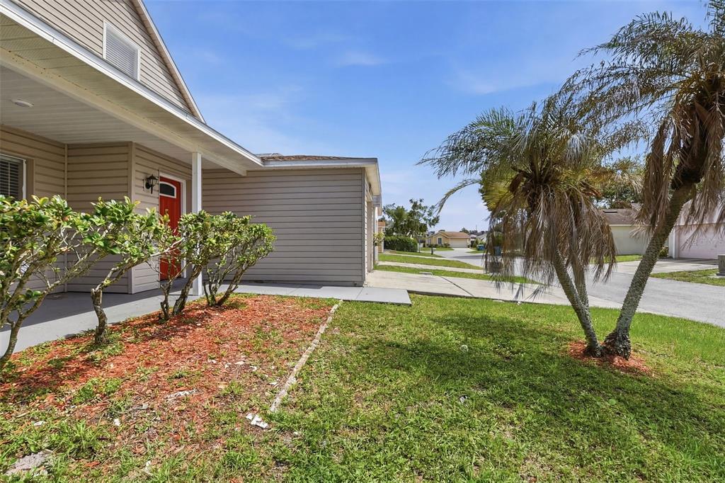A tan house with a red front door, a palm tree, and a grassy lawn — 617 GREYS FERRY ROAD, ORLANDO, FL