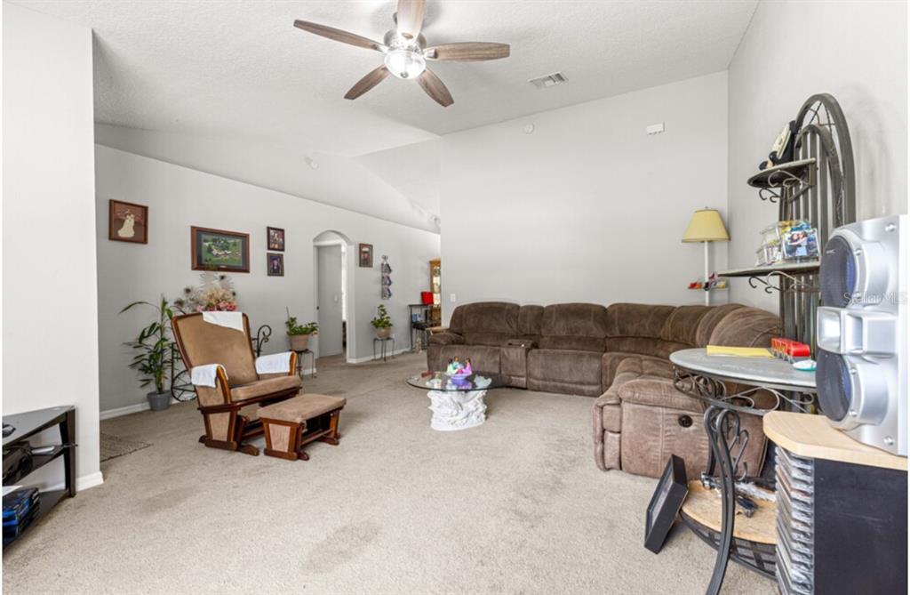 A living room features a brown sectional sofa, a rocking chair, and a ceiling fan — 1423 W HAWK LANE, CITRUS SPRINGS, FL