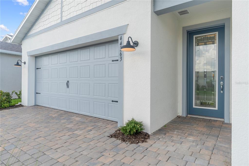 A paved driveway leads to a garage and a blue front door with glass panels — 44363 KELLY DRIVE, PUNTA GORDA, FL