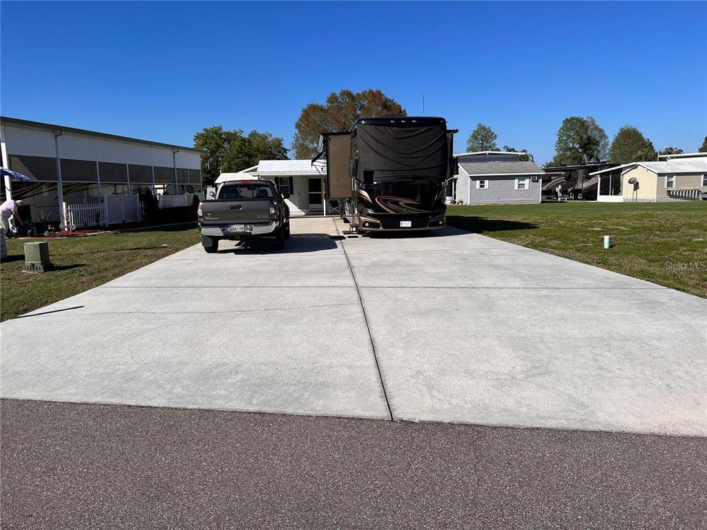 A concrete driveway features a parked pickup truck and a large motorhome in front — 5062 SOUTHSHORE DRIVE, POLK CITY, FL
