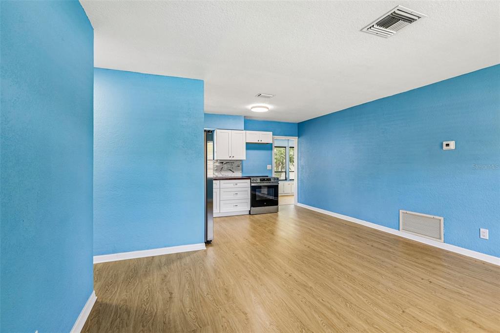 A kitchen features white cabinets, stainless steel appliances, a dark countertop, and bright blue walls — 104 E GRAPEFRUIT CIRCLE, CLEARWATER, FL