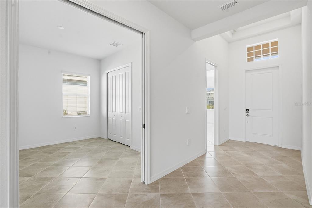 An interior view shows a tiled entryway leading to a bedroom with a closet and door — 19715 TROUT TERRACE, LAKEWOOD RANCH, FL