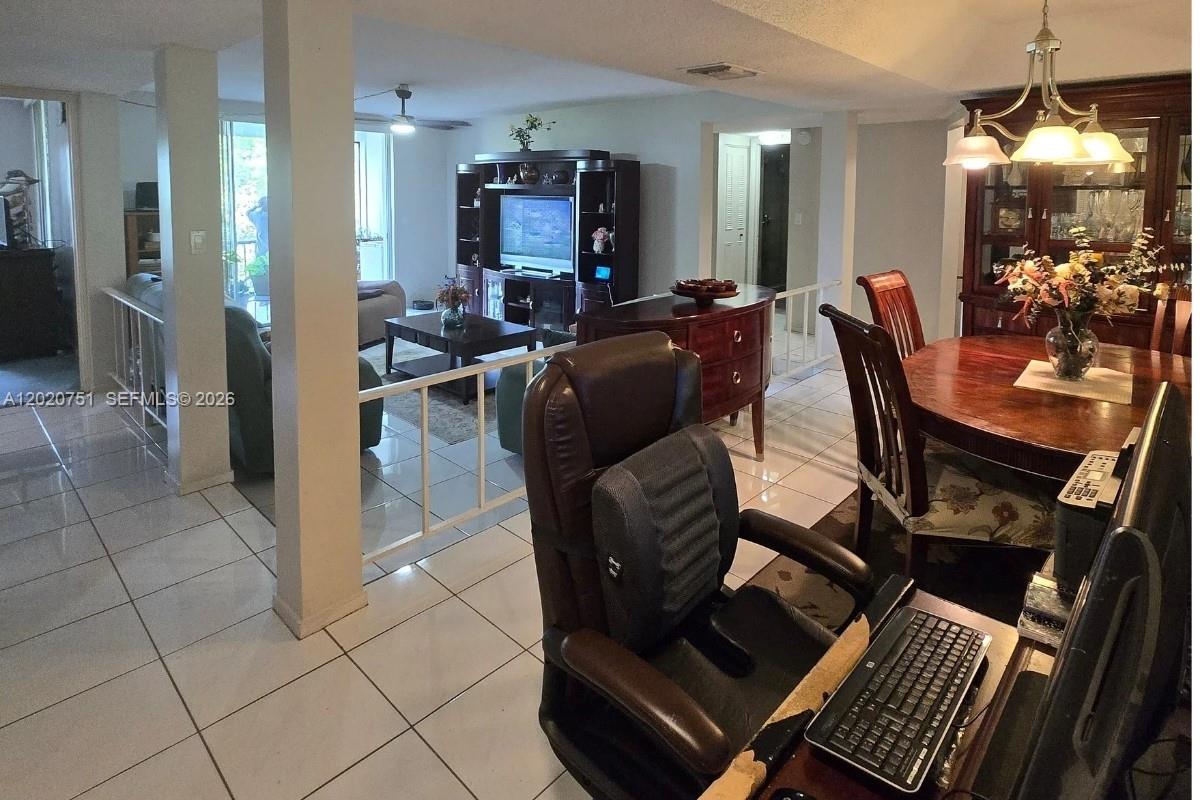 A view of an open-concept living and dining area with tile flooring and white railings — LAUDERHILL, FL
