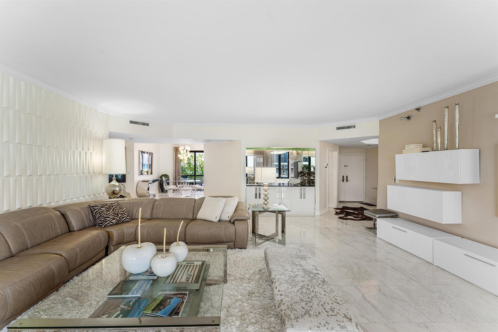 A spacious living room features a large leather sectional, white marble floors, and modern cabinetry — 3120 S Ocean Boulevard # 202, Palm Beach FL 33480, PALM BEACH, FL