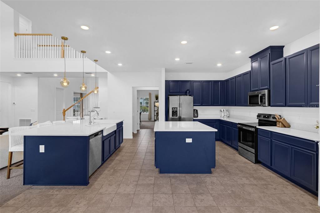 A kitchen features dark blue cabinets, white countertops, two islands, and tile flooring — 2901 AGOSTINO TERRACE, KISSIMMEE, FL