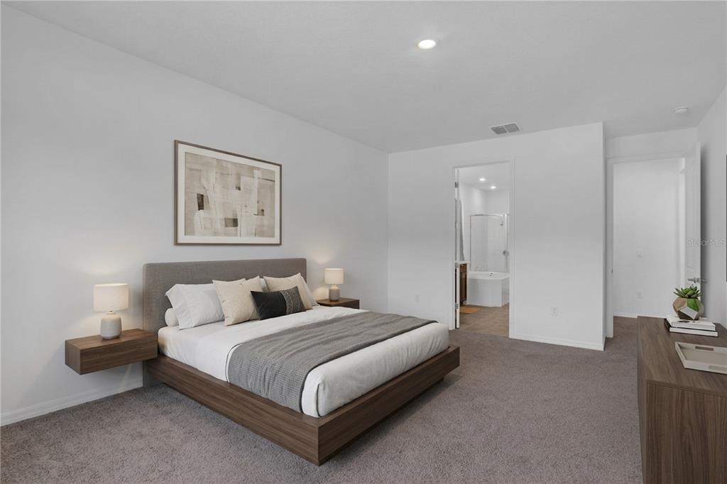 A bedroom features a platform bed, floating nightstands, gray carpeting, and an attached bathroom — 2901 AGOSTINO TERRACE, KISSIMMEE, FL
