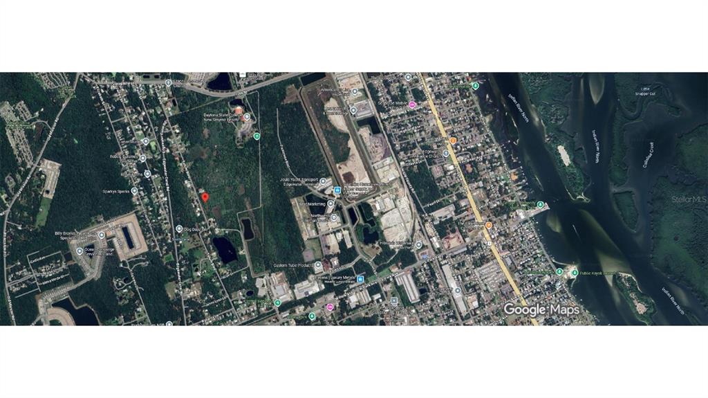 This is an aerial map view showing a wooded lot with a red location marker — 1705 TATUM BOULEVARD, NEW SMYRNA BEACH, FL