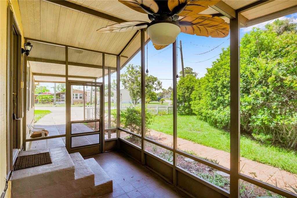 A screened-in porch features a ceiling fan, tiled steps, and a view of the yard — 120 NIVER STREET, PORT ORANGE, FL