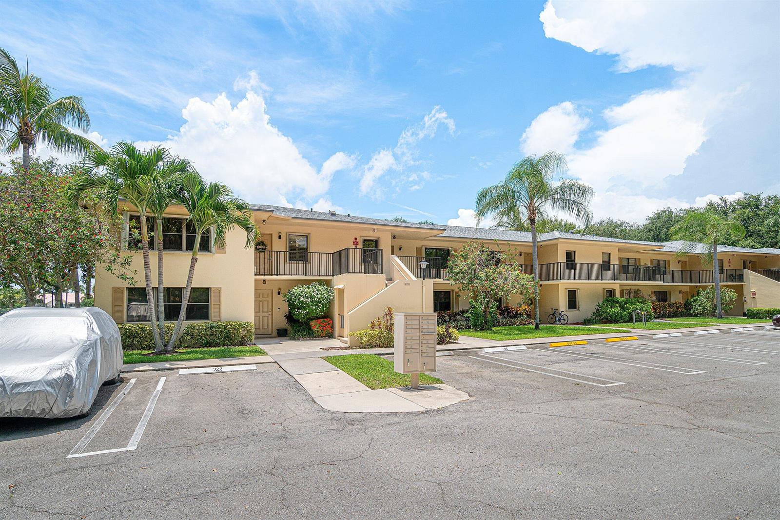 A two-story apartment building with a parking lot, palm trees, and a central mailbox unit — 2898 SW 22nd Circle # 232a, Delray Beach FL 33445, DELRAY BEACH, FL
