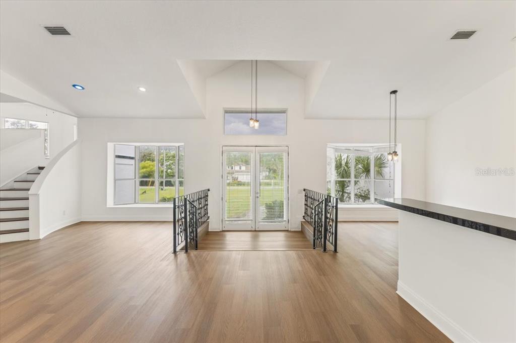 A bright living area features vaulted ceilings, hardwood floors, and a central double-door entryway — 12001 LAKE BUTLER BOULEVARD, WINDERMERE, FL