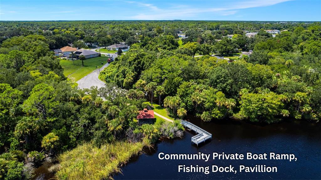 An aerial view shows a community pavilion, fishing dock, and boat ramp near a lake — 846 MARLEY DRIVE, PORT ORANGE, FL